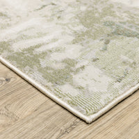 Caravan Beige & Green Contemporary Rug with textured polyester yarns on a wooden floor.