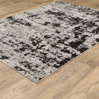 Caravan Grey & Black Contemporary Rug with abstract, textured design on a light wood floor.