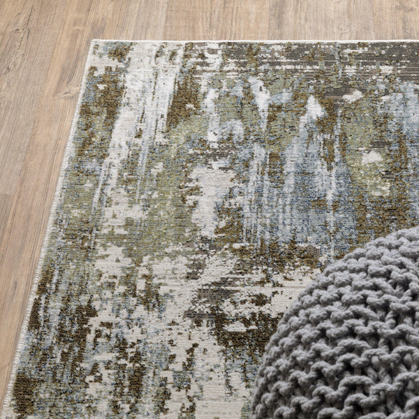 Caravan Moss Green & Blue Contemporary Rug with textured, multi-level surface and a gray knitted pouf.