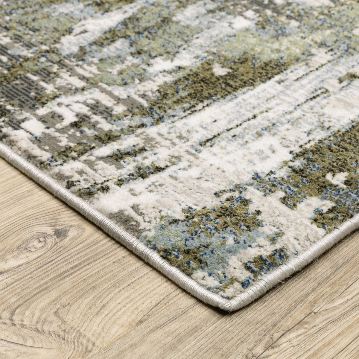 Caravan Moss Green & Blue Contemporary Rug with textured, multi-level surface on a wooden floor.