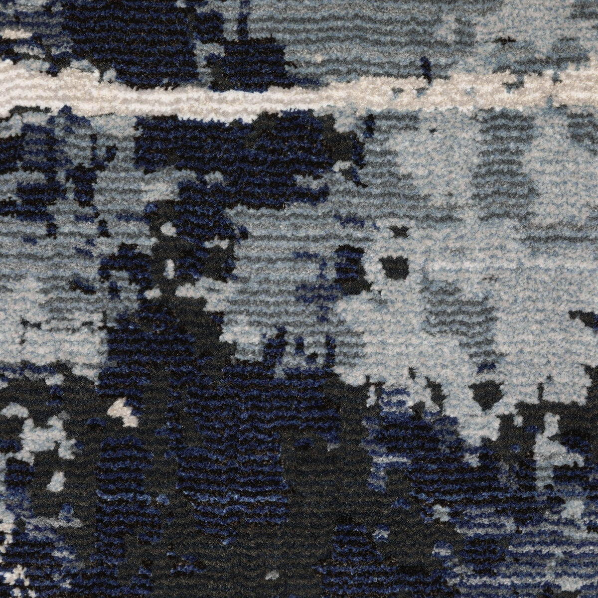 Close-up of a Caravan Multi-Blue Contemporary Rug with textured, multi-level polyester yarns in warm and cool tones.
