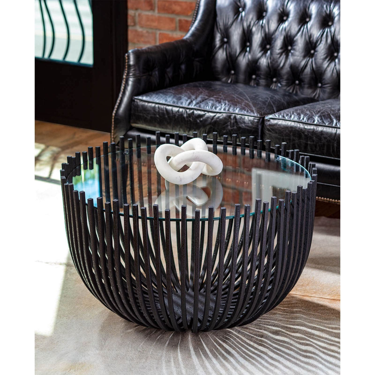 White abstract marble sculpture, 5.5"H x 8"W, on a modern glass and metal coffee table.