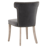 Dark dove gray velvet dining chair with sculpted wingback design, brass nailhead trim, and light wood legs.