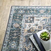 Charleston Blue & Ivory washable rug with distressed traditional design, on a wood floor, next to books and a succulent.