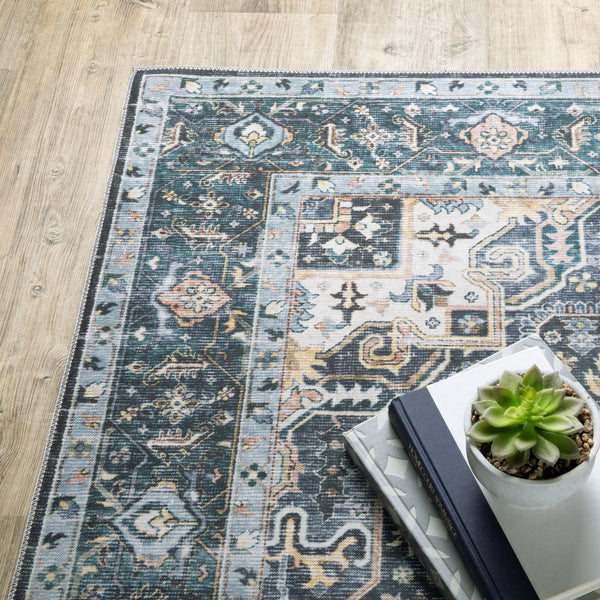 Charleston Blue & Ivory washable rug with distressed traditional design, on a wood floor, next to books and a succulent.