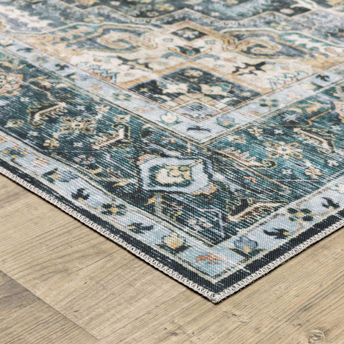 Charleston Blue & Ivory washable rug with distressed traditional design on light wood floor.
