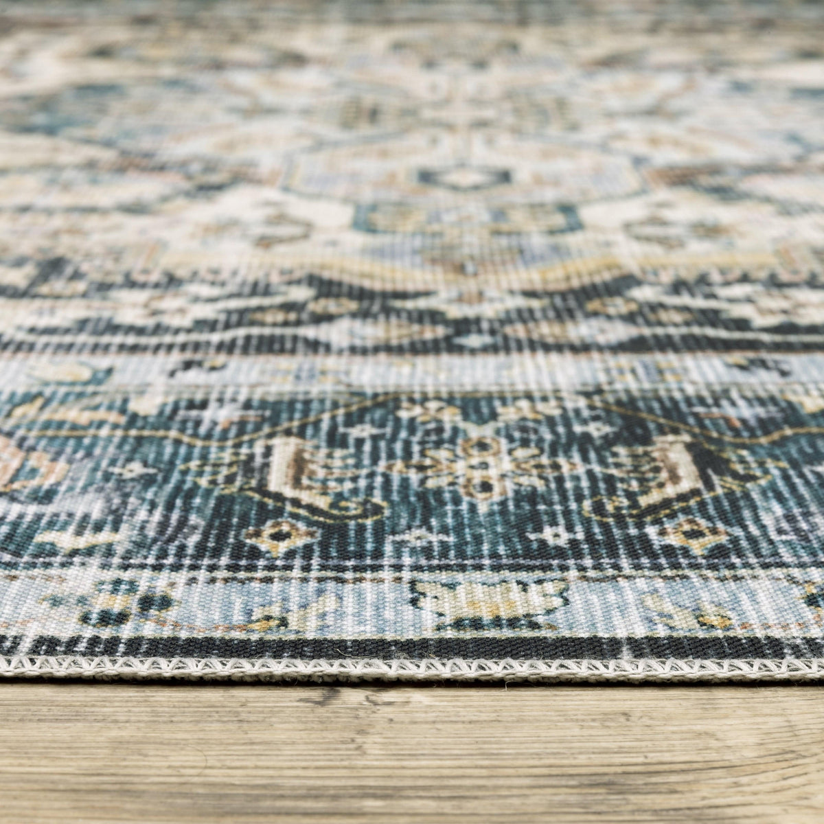 Charleston Blue & Ivory washable polyester rug with distressed traditional design on a wood floor.