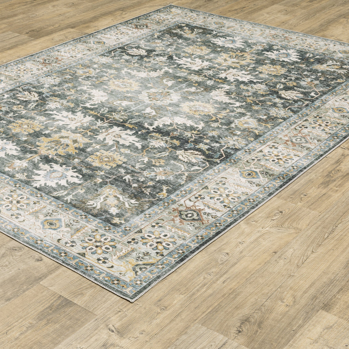 Charleston Charcoal & Gold Washable Rug with distressed traditional patterns on a wood floor.