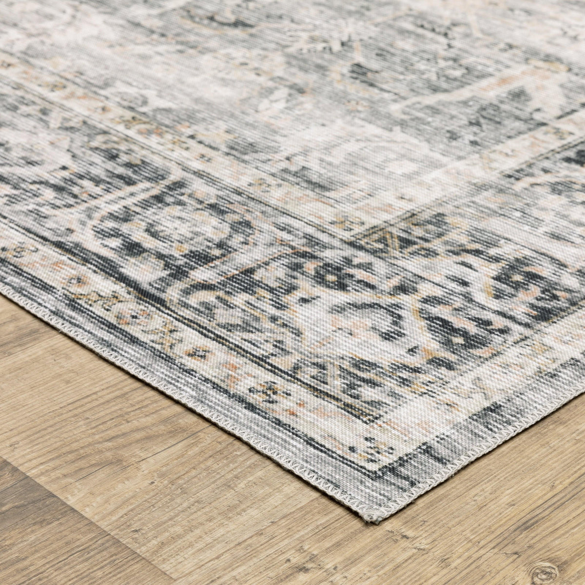 Charleston Charcoal & Grey Washable Rug with intricate medallion pattern on a light wood floor.