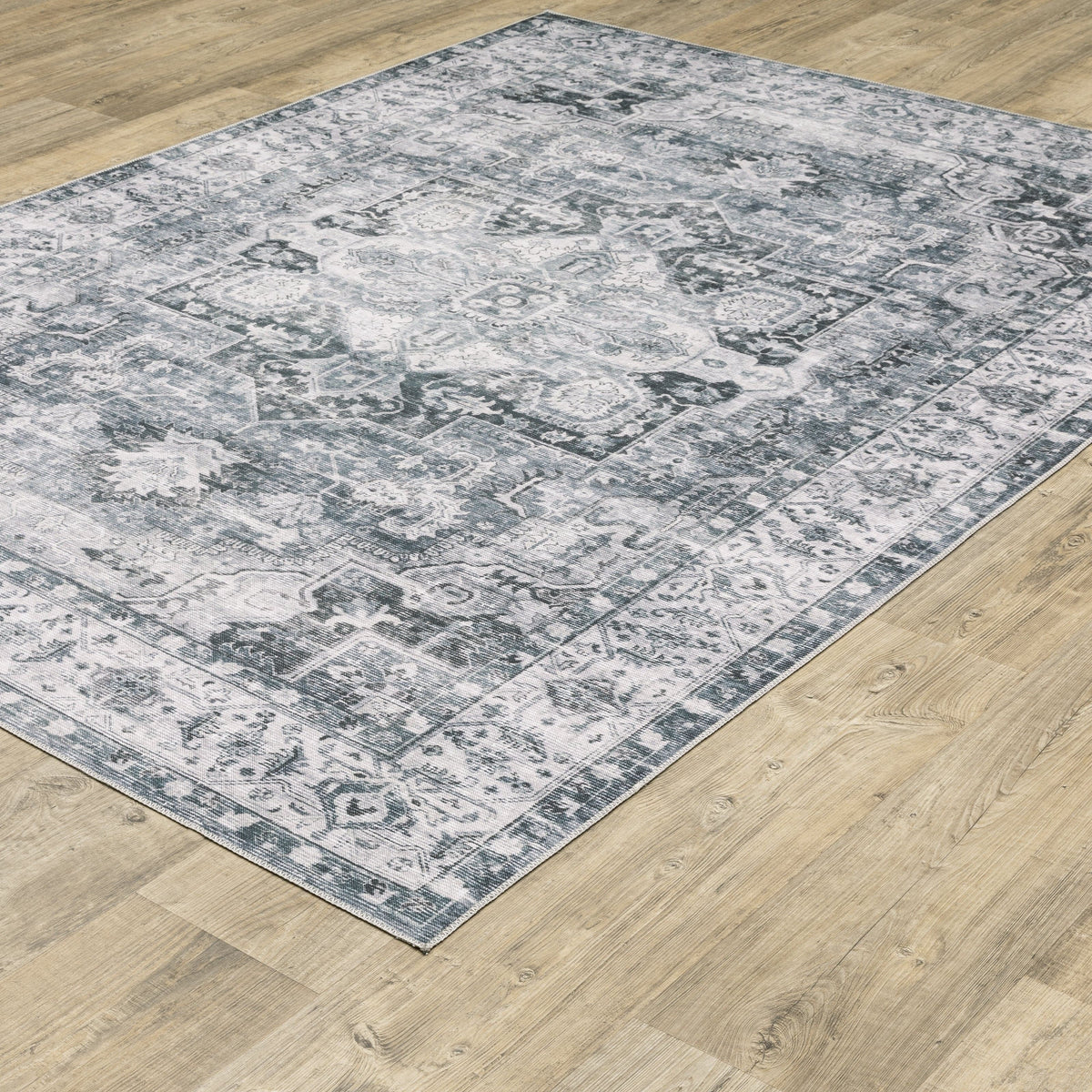 Charleston Charcoal & Ivory Washable Rug with distressed traditional patterns on a wood floor.