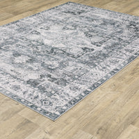 Charleston Charcoal & Ivory Washable Rug with distressed traditional patterns on a wood floor.
