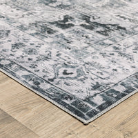 Charleston Charcoal & Ivory Washable Rug with distressed traditional patterns on a wood floor.