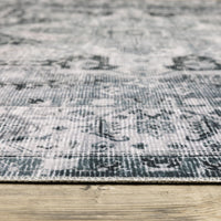 Charleston Charcoal & Ivory Washable Rug with distressed traditional patterns on a wooden floor.