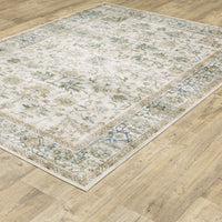 Charleston Ivory & Multi-Color Washable Rug with distressed traditional patterns on a wood floor.