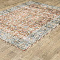 Charleston Rust & Blue washable rug with distressed traditional patterns on a wood floor.