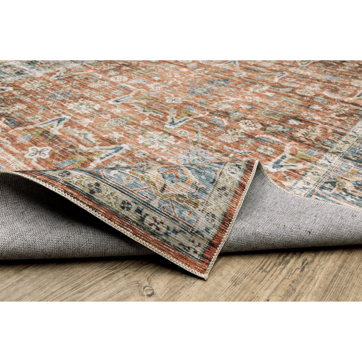 Charleston Rust & Blue washable polyester rug with distressed traditional patterns and non-slip backing on wood floor.