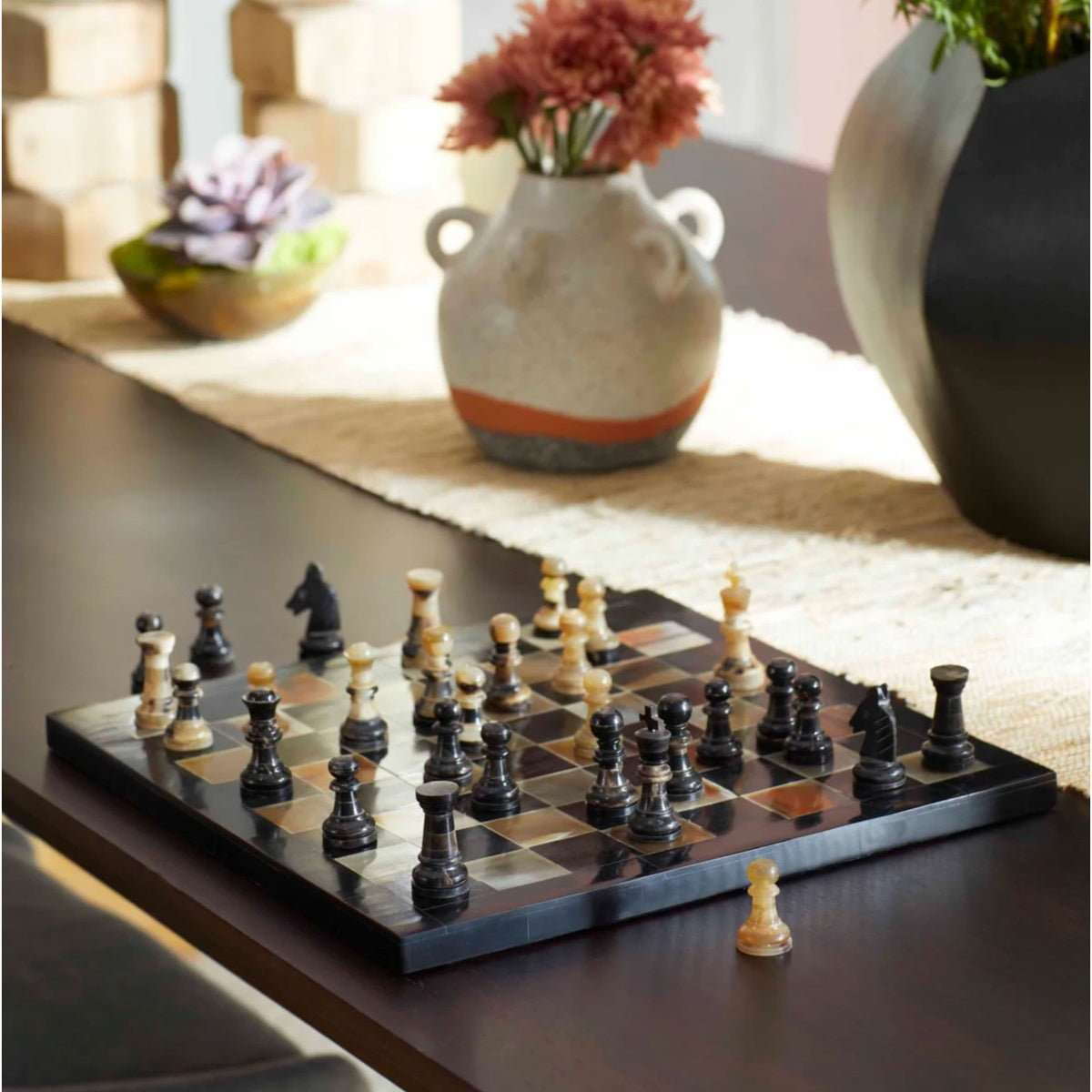 Stylish black and tan horn and resin chess board with classic checkerboard pattern and textured finish.