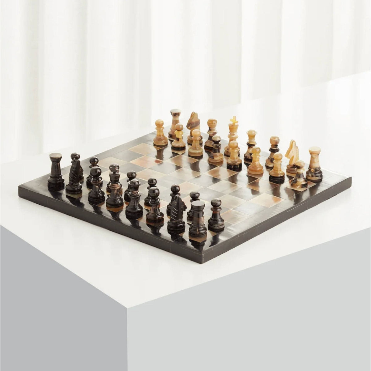 Stylish black and tan horn and resin chess board with classic checkerboard pattern and full set of pieces.