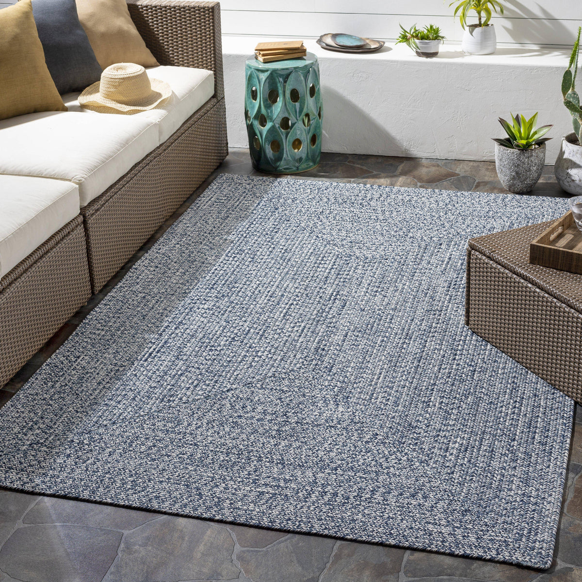 Chesapeake Bay blue and cream braided polypropylene outdoor rug on a patio.