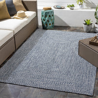 Chesapeake Bay blue and cream braided polypropylene outdoor rug on a patio.