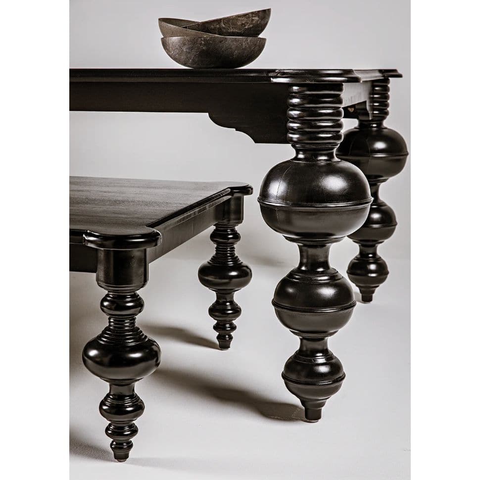 Claudio black mahogany dining table with turned legs and rounded corners.