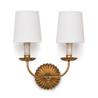 Antique gold leaf double sconce with ribbed backplate, two white linen shades, and candelabra bases.