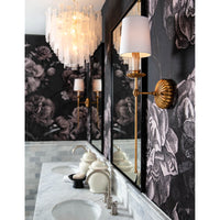 Antique gold leaf Clove sconce with a white linen shade on a dark floral wallpaper.