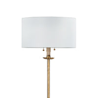 Clove Stem Floor Lamp with antiqued gold leaf finish and a natural linen shade.