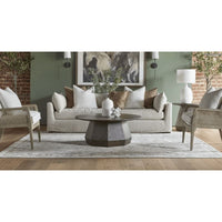 Coulter Burnished Brown Coffee Table: round, dark wood with faceted base, centered in a stylish living room.