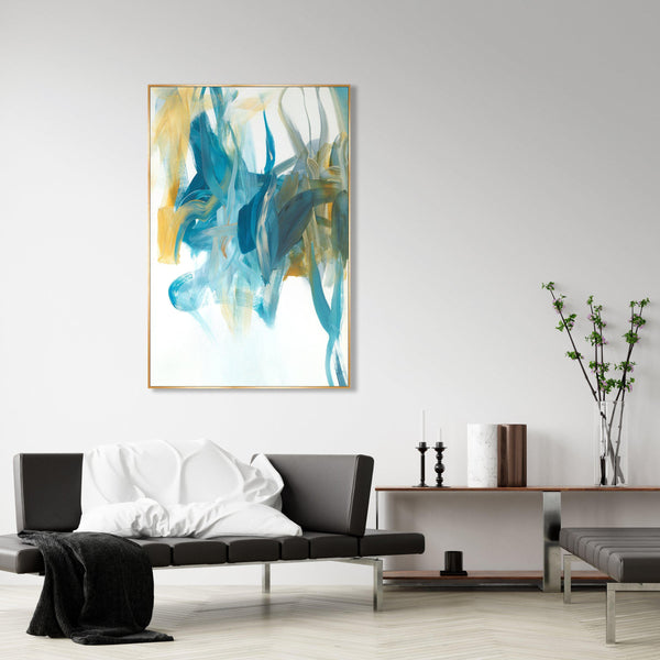 Abstract giclee canvas painting with blue, teal, and gold brushstrokes in a gold frame above a modern sofa.