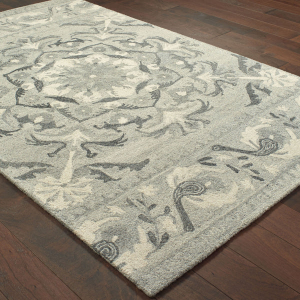 Heathered gray and ivory casual rug with a hand-tufted floral pattern on dark wood flooring.