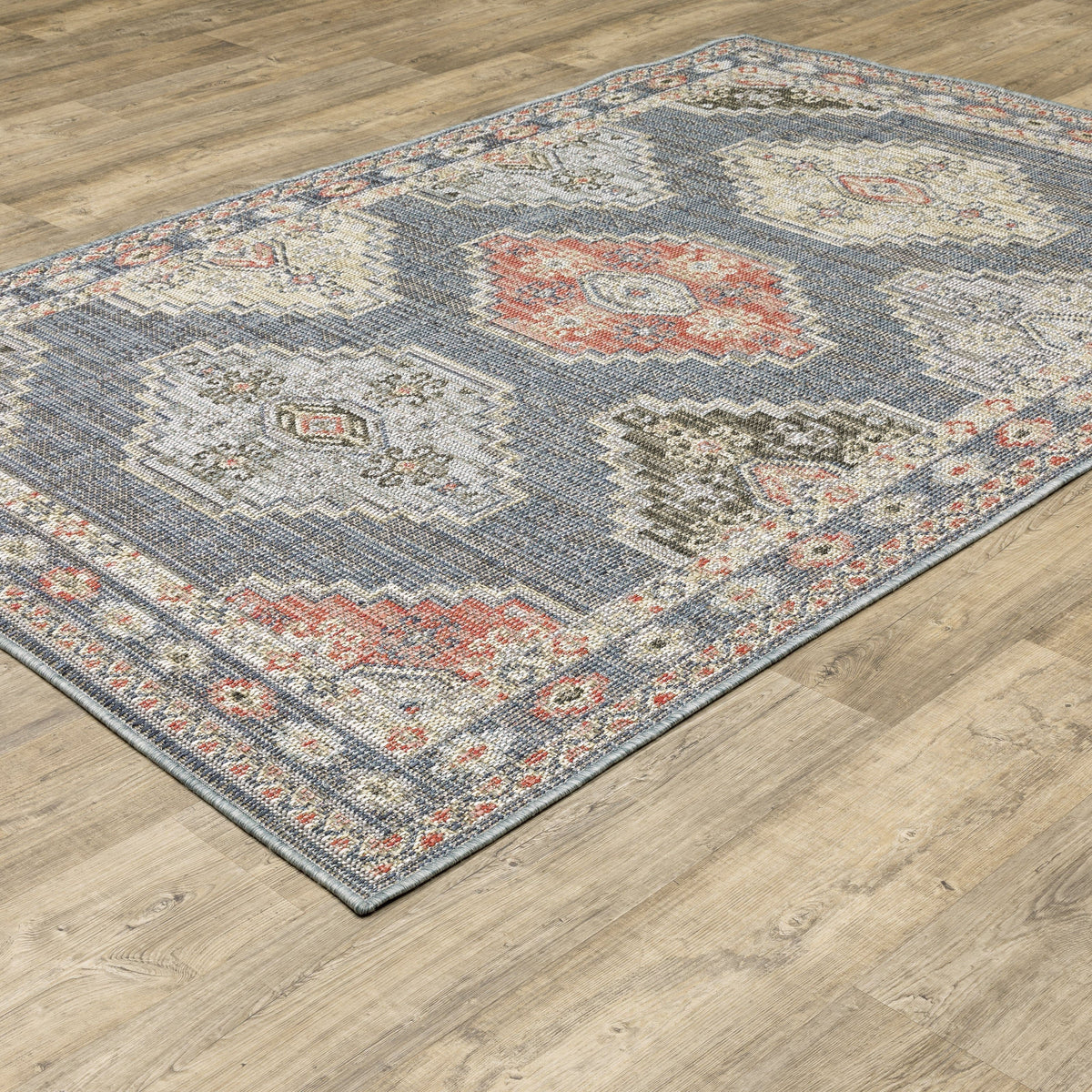 Cyprus Blue & Multi Outdoor Rug with traditional Persian and geometric patterns on a wood floor.