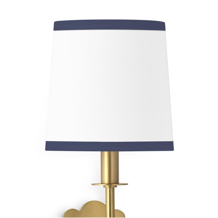 Daisy Sconce with a natural linen shade, navy trim, and a natural brass daisy-shaped backplate.