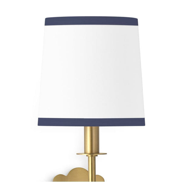 Daisy Sconce with a natural linen shade, navy trim, and a natural brass daisy-shaped backplate.