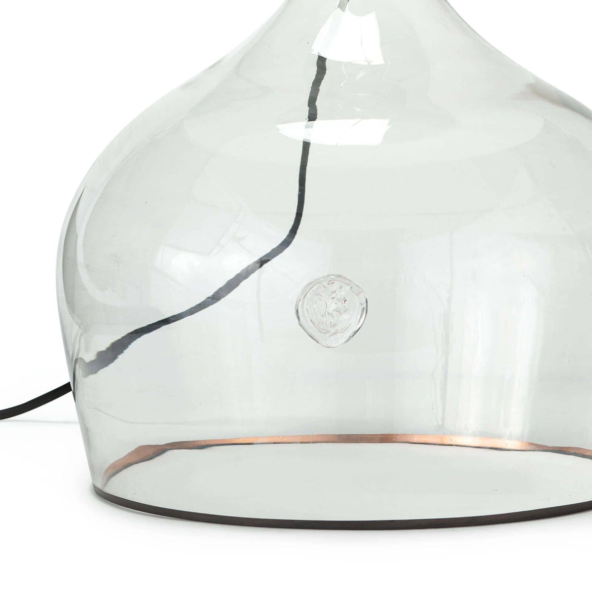Large clear glass demi john lamp base with a copper stripe and black cloth cord.