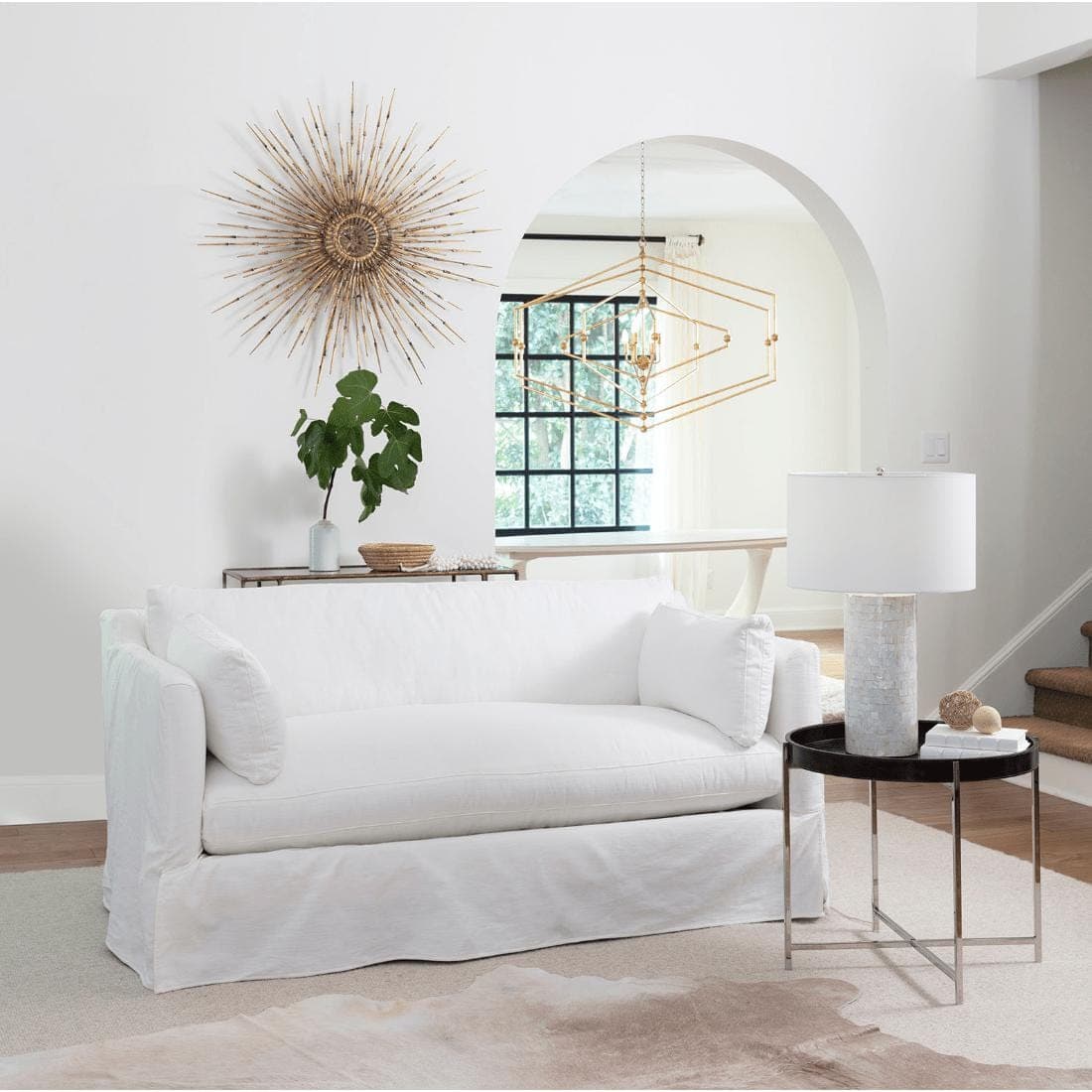 Black leather tray end table with a polished nickel frame next to a white sofa.