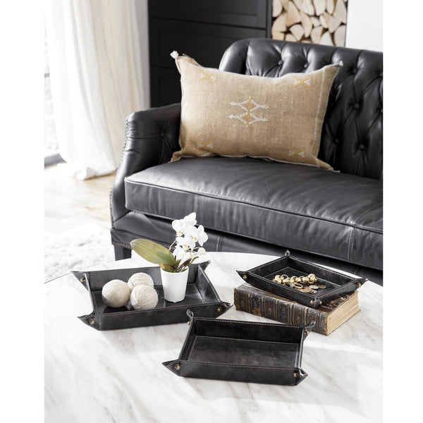 Derby brown leather nesting tray set with brass snaps, displayed on a marble table.