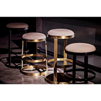 Four Dior Bar Stools with soft linen seats and circular metal bases, two black steel and two antique brass.
