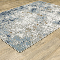 Easton Blue & Ivory Casual Rug with textured abstract design in blue, gray, and ivory on a wood floor.