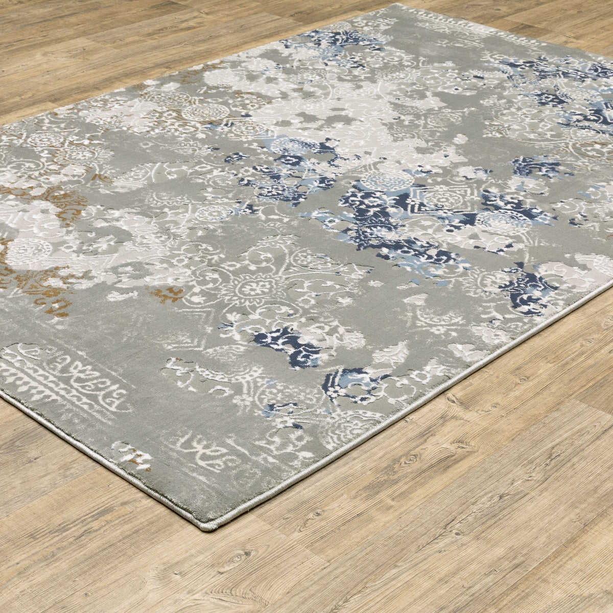 Easton Grey & Blue Casual Rug with textured abstract design on a wooden floor.