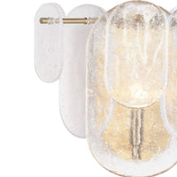 Modern Echo sconce with natural brass hardware and textured water glass panes, emitting a soft glow.