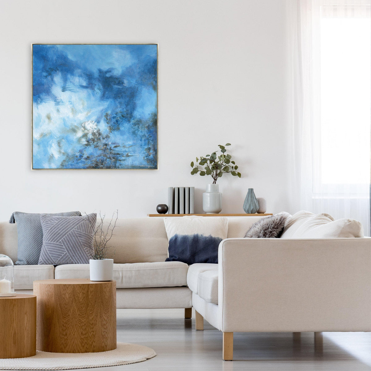Ethereal Blue Giclee Canvas Painting, an abstract artwork with cool tonal depth, displayed above a cream sectional sofa.