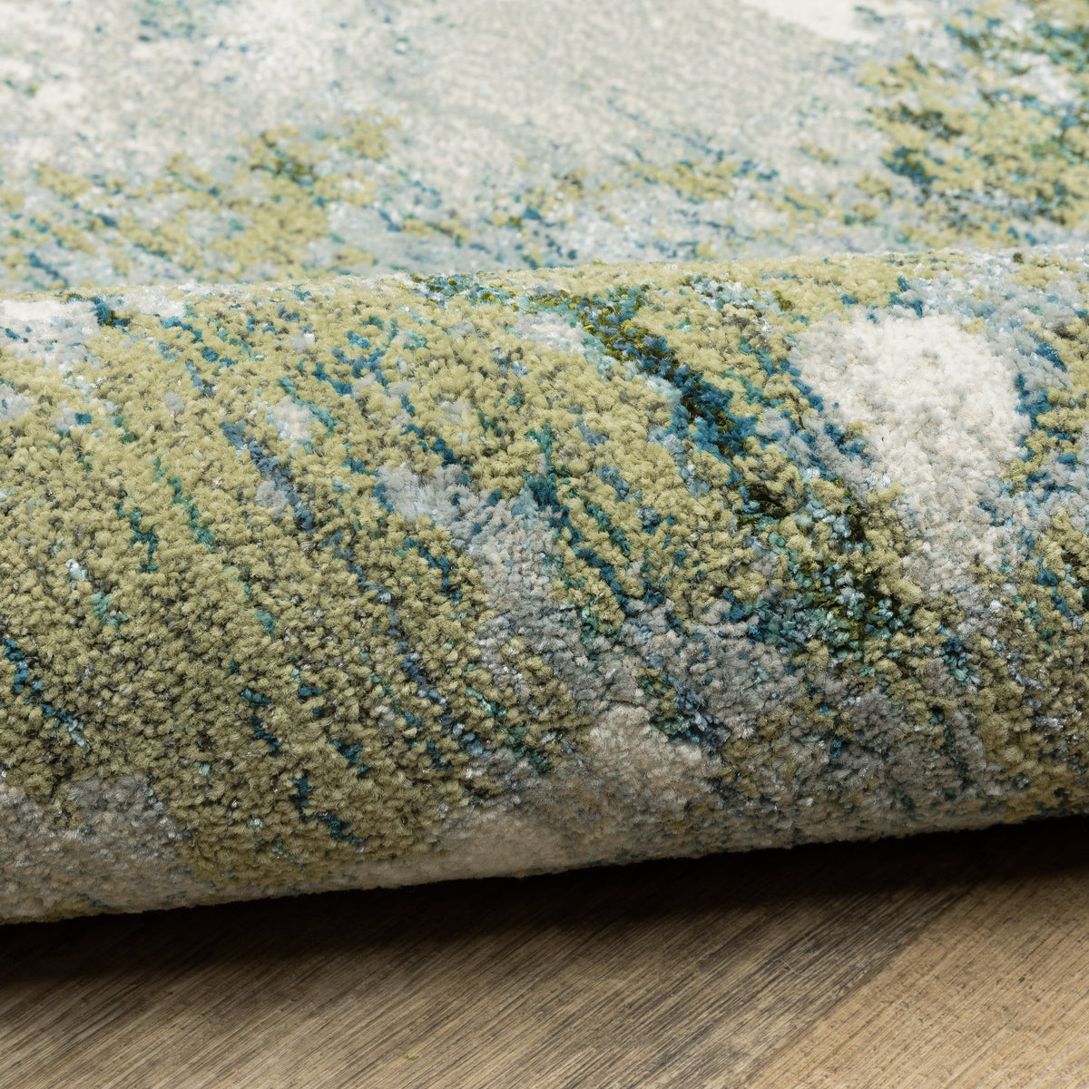 Close-up of an Evolution Blue & Green Contemporary Rug, showing textured nylon/polypropylene fibers.