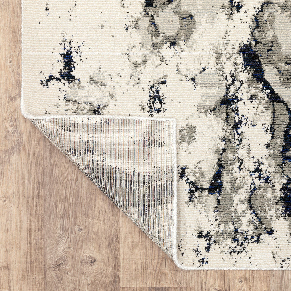 Evolution Contemporary Rug, ivory, charcoal & black, with a corner folded to show woven polypropylene backing.