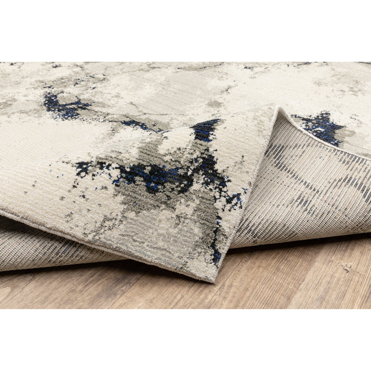 Evolution Contemporary Rug: Ivory, Charcoal & Black with abstract blue accents, power-loomed nylon/polypropylene blend.
