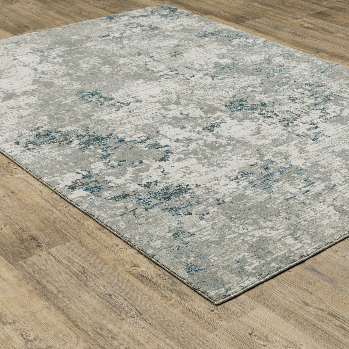 Evolution Grey & Blue Contemporary Rug with abstract landscape design on a wood floor.