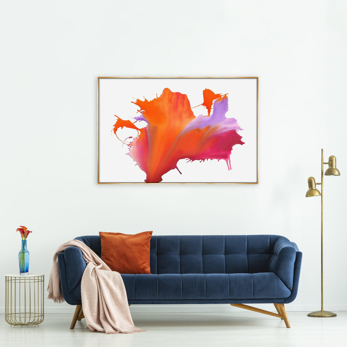 Abstract "Fire My Soul II" giclee canvas by Van Garret, featuring bold orange, pink, and purple hues in a gold frame, above a navy velvet sofa.