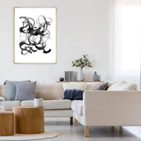 Abstract black and white giclee canvas art with brush gel finish in a gold frame, above a cream sectional.
