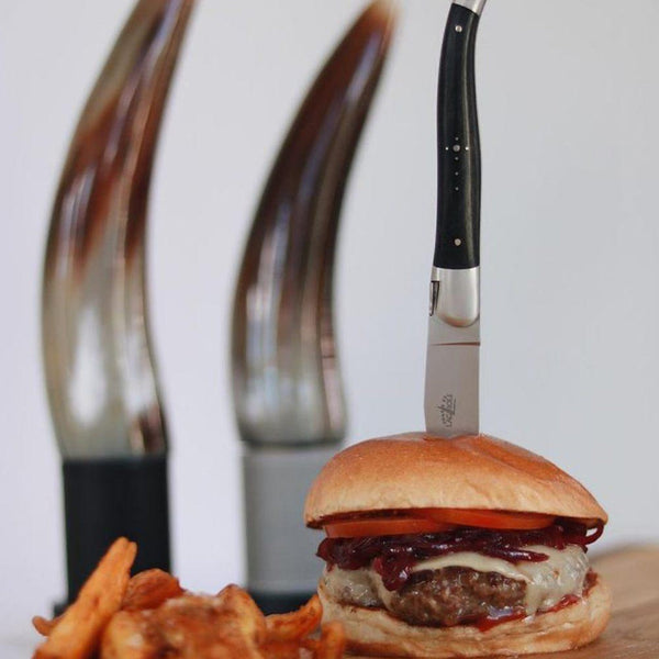 Hamburger with a knife sticking out on a white background