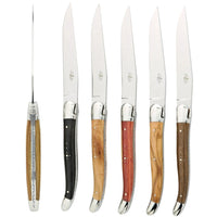 Set of steak knives with wooden handles on a white background
